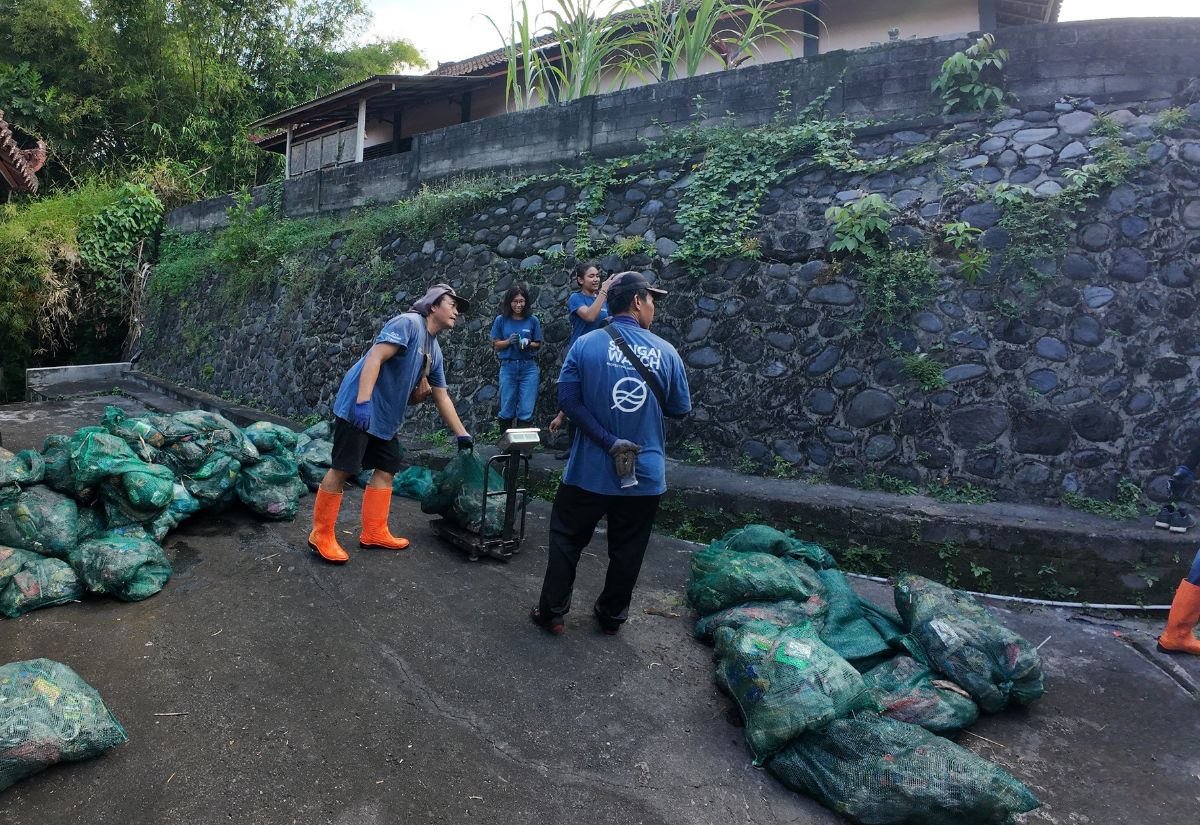 team weighing trash collected from waste site